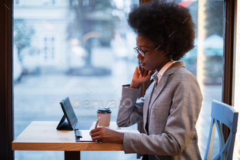 Successful business lady sitting at cafe with tablet / Photodune, Misc
