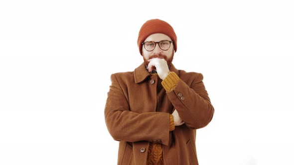 Attractive Millennial Man Makes Thinking Gesture with a Hand Looks Away and Puts the Hands Down