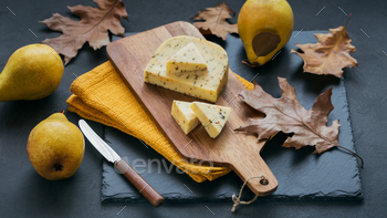 Cheese with herb in a cutting board on dark background. / Photodune, Misc