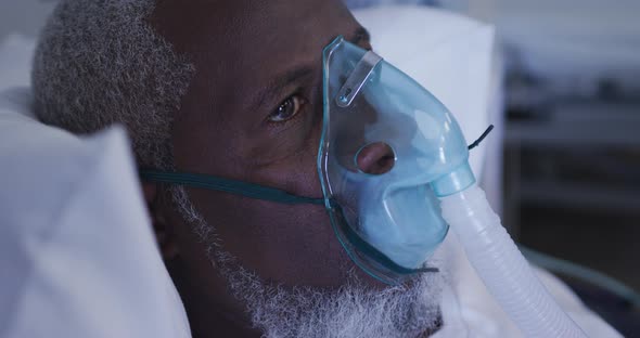 African american male patient in hospital bed wearing oxygen masks