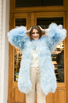 nd makeup posing in pink and blue lama fur coat at Milan street. City fashion. Trendy girls