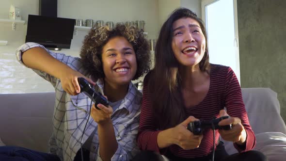 Two Girlfriends Play with Joysticks
