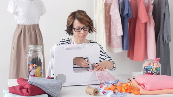 Small Business and Hobby Concept. Fashion Designer Working on Her Designs in the Bright Studio