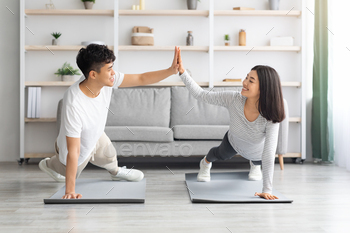 Joyful asian man and woman cheering up while planking / Photodune, Misc