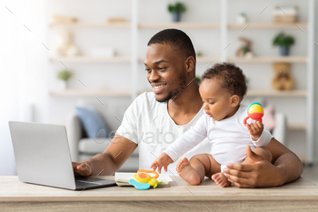 Paternity Leave. Black Man Using Laptop At Home And Babysitting Infant Child / Photodune, Misc