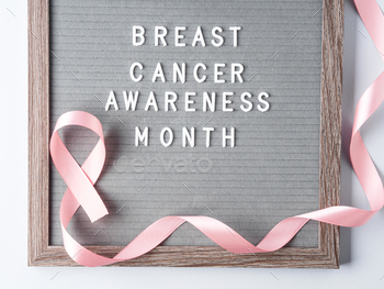 Breast cancer awareness month written on letter board and pink ribbon symbol on gray background / Photodune, Misc