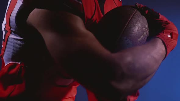 Faceless Determined Professional American Football Player in Helmet Holding a Ball in Hands