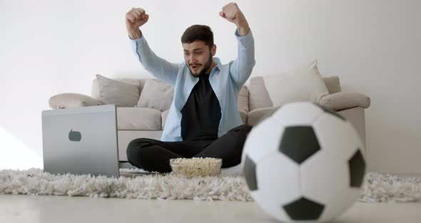 A Young Indian Football Fan is Watching TV at Home