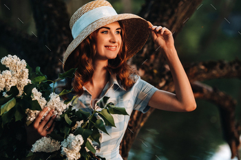 Portrait of a beautiful girl with long hair, a straw hat and a long summer dress with lilac flowers / Photodune, Misc