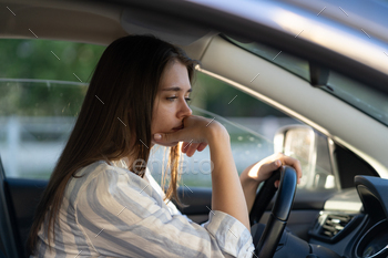 Drunk girl driving car. Unhappy tired young female in vehicle suffering from headache or handover / Photodune, Misc
