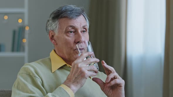 Senior Pensive Old Mature Caucasian 60s Man Ill Aged Male Thinking Relaxing at Home Holding Glass of