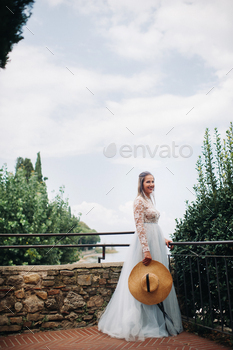 a girl with a hat in a white dress stands in the old town of Sirmione.Italy / Photodune, Misc