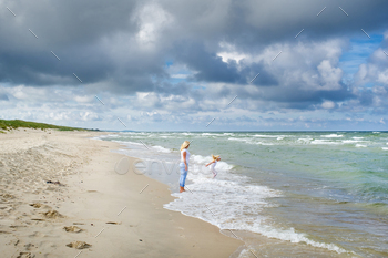 Mom and daughter walk together along the shores of the Baltic Sea in Lithuania / Photodune, Misc