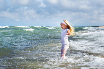 Happy Little girl in clothes on the Baltic Sea beach on the Curonian spit in Lithuania / Photodune, Misc