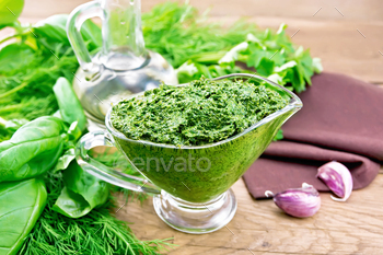 Sauce of spicy greens in gravy boat on old board / Photodune, Misc
