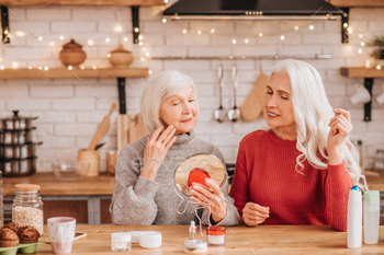 Two good-looking elderly women trying new cream / Photodune, Misc