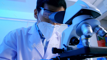 Asian scientist doing some research and looking through a microscope in laboratory. / Photodune, Misc