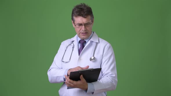 Mature Handsome Man Doctor Against Green Background