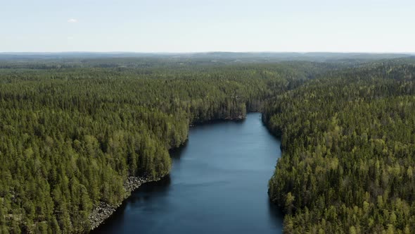 Aerial  tracking, drone shot panning over lake Iso Helvetinjarvi, bright, sunny day, in Helvetinjarv