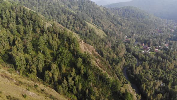 Aerial Video From Flying a Drone Over Small Village in High Mountain Forest