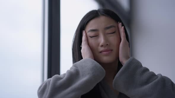 Portrait of Exhausted Tired Asian Young Woman Rubbing Temples in Slow Motion