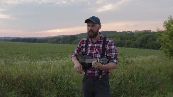 Caucasian Man Sings Nad Plays on Guitar