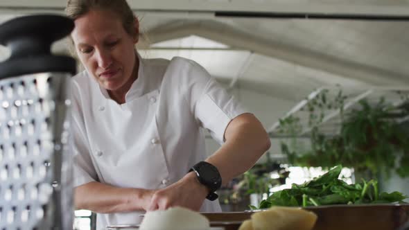 Caucasian female chef mixing dough in a bowl