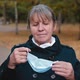 Portrait of a Senior Woman Putting on a Medical Mask and Looking Seriously at the Camera. - VideoHive Item for Sale
