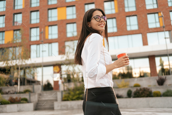 Woman in white shirt holding a coffee to go / Photodune, Misc