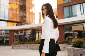 Beautiful woman in white shirt on business buildings background / Photodune, Misc