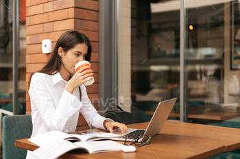 ラップトップに取り組んでいる間行くためにコーヒーを飲むブルネットの女性 / Photodune, Misc