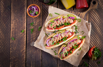 Hot dog with  pickles, tomato and lettuce on wooden background / Photodune, Misc