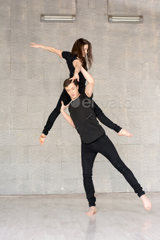 Young couple practices acrobatic balance. / Photodune, Misc