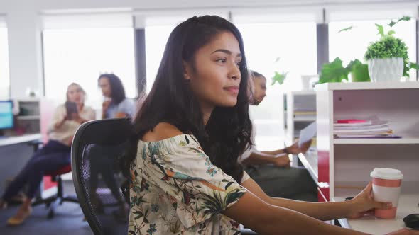 Professional businesswoman smiling while sitting on her desk in modern office in slow motion