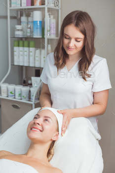 Professional cosmetology procedures. The beautician puts a headband on the client's girl. / Photodune, Misc