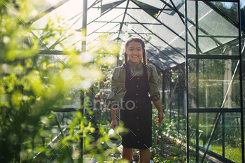 カメラを見て、裏庭の屋外の温室でガーデニング幸せな小さな女の子 / Photodune, Misc
