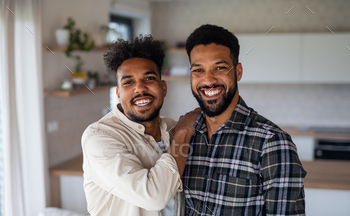 Young adult brothers in kitchen indoors at home, looking at camera / Photodune, Misc