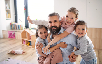 Father with three daughters indoors at home, looking at camera / Photodune, Misc