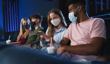 映画館、コロナウイルスの概念でスマートフォンと陽気な若いカップル / Photodune, Misc