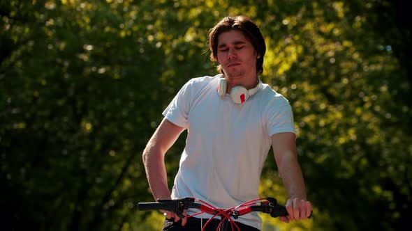 Young Man Riding a Bike Looking at His Phone