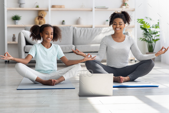 Cheerful black mom and daughter having online yoga class / Photodune, Misc