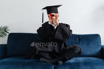  male student with diploma at home showing his emotions