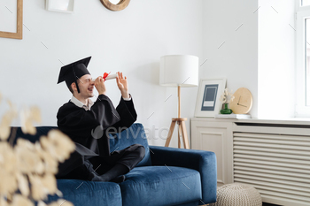  male student with diploma at home showing his emotions