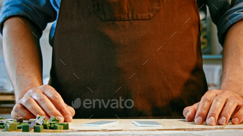 A man in a work uniform at a table / Photodune, Misc