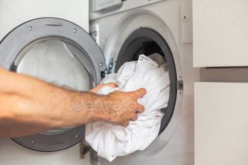 Housework: Man loading clothes into washing machine / Photodune, Misc
