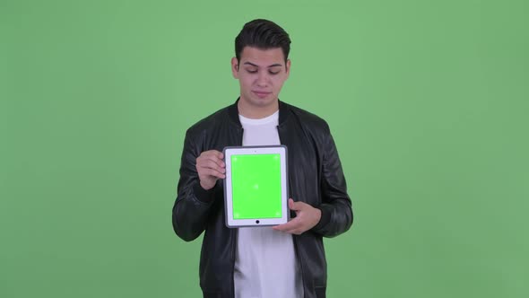 Stressed Young Multi Ethnic Man Showing Digital Tablet