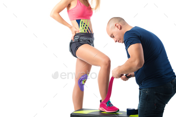 A man cuting kinesio bright tapes on the woman's leg / Photodune, Misc
