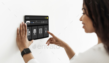 Pretty woman using smart home device, pushing button on pad / Photodune, Misc
