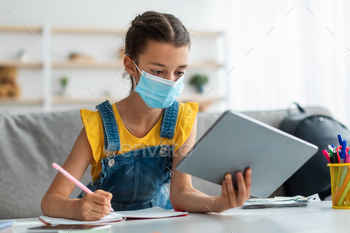 Girl in disposable mask studying at home with digital tablet / Photodune, Misc
