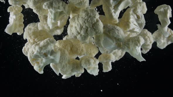 Cauliflower Falling Into Water on Black Background